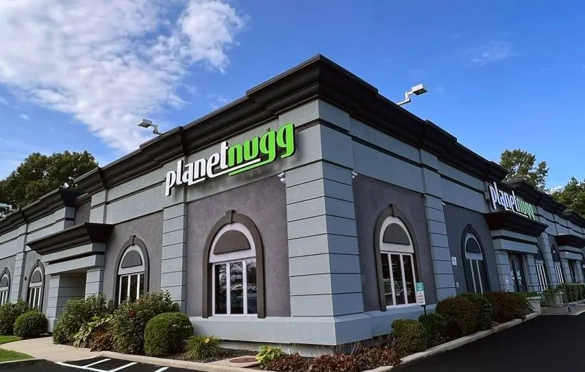 Planet Nugg dispensary exterior with green sign and arched windows in Farmingdale